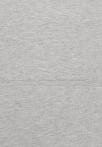 Heller grauer Sweatshirtstoff mit subtiler Melange-Textur. Er verfügt über einen geraden Saum und eine glatte Oberfläche mit minimalen Nähdetails.