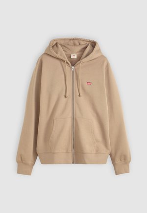Beige zip-up hoodie, cotton material, adjustable drawstring hoodie, front pockets, small red logo on chest, ribbed cuffs and hem.