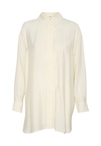 Kreemikas oversized-särk klassikalise kraega, ees nupuga sulgemine ja pikad varrukad, millel on sile, kergelt tekstuuriga kangas.