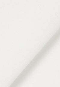 Tissu en toile blanche avec une surface texturée, présentant un pli net et lisse. Le matériau semble durable et polyvalent pour diverses applications.