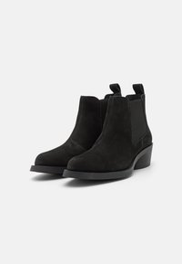 Botines de ante negro con un diseño elegante, punta redondeada, paneles elásticos laterales, dos tiradores y un tacón bajo de bloque.