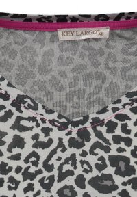 Gray top with a black leopard print pattern, featuring a V-neck and a pink trim. Made from soft, textured fabric. Brand label at neck.
