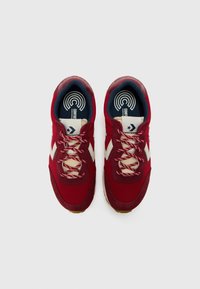 Baskets en maille rouge et en daim avec des accents crème, des lacets ronds et une semelle intérieure à motifs. Présente un bout arrondi et une semelle texturée.