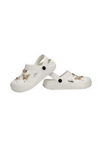 Sabots blancs à enfiler avec des brides arrière et des charms décoratifs en forme de papillon attachés aux évents supérieurs perforés.