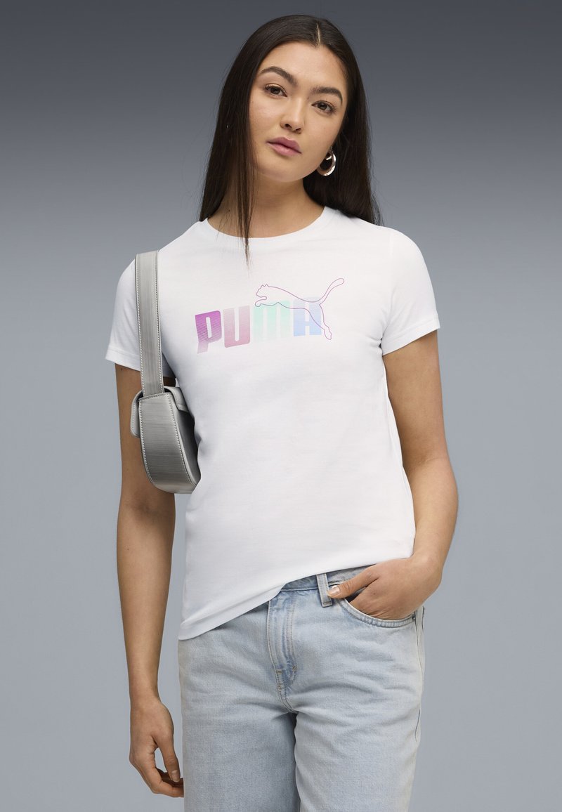 Hvid bomulds T-shirt med et flerfarvet "PUMA" logo. Model med lyseblå jeans og en grå taske med rem.