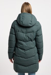 Abrigo de plumas de color verde oscuro con capucha, que presenta un diseño acolchado y un patrón de chevrón en la parte posterior. Tejido suave y texturizado, con corte a media longitud.