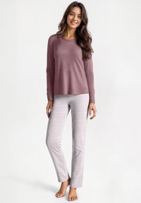 Top a maniche lunghe in malva con vestibilità rilassata, abbinato a pantaloni grigi chiari a righe con sottili linee rosse, texture liscia e design alla caviglia.
