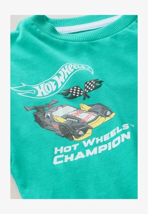 Tricou turcoaz cu guler rotund, având un grafic cu o mașină de cursă, steaguri în carouri și textul "Hot Wheels Champion" în alb.
