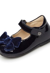 Granatowe lakierowane buty typu Mary Jane z aksamitnym detalem w postaci kokardy, zaokrąglonym noskiem i regulowanym zapięciem. Gładkie wykończenie wnętrza.