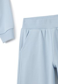 Lichtblauwe trainingsbroek met een geribde tailleband, zijzakken en een zachte katoenmix textuur. Ontworpen voor comfort en casual gebruik.