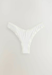 Weiße Spitzen-String-Tanga aus weichem Stoff, mit gewellten Kanten entlang des Bundes und der Beinausschnitte, mit einer glatten Oberfläche.