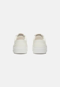 Sneaker bianche con tomaia in pelle liscia, dettagli in suede sul tallone e una robusta suola in gomma bianca progettata per il comfort.