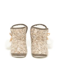 Pantuflas de punto con un patrón beige y crema, que cuentan con un interior esponjoso, acentos grises y un lazo decorativo con un pompón en cada lado.