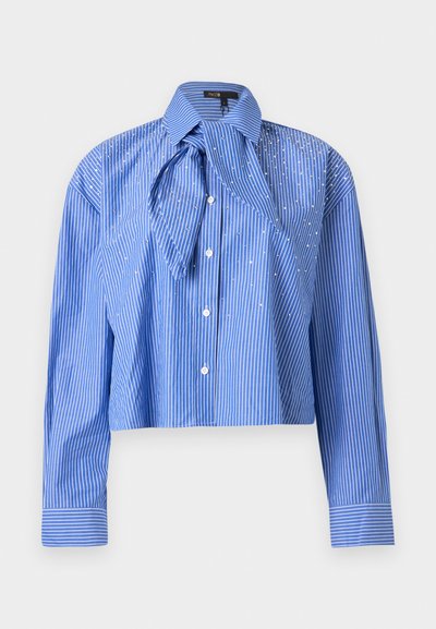 Chemise bleue courte à rayures verticales blanches, manches longues, boutonnée à l'avant, avec un grand col oversize et un détail en tissu noué.