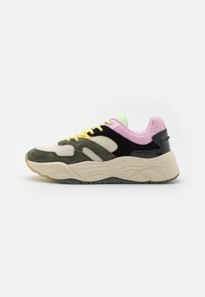 Niski sneaker z warstwowymi zielonymi, czarnymi, beżowymi i różowymi panelami z siateczki i zamszu, żółtymi sznurówkami i grubą kremową podeszwą, widok z boku na białym tle.