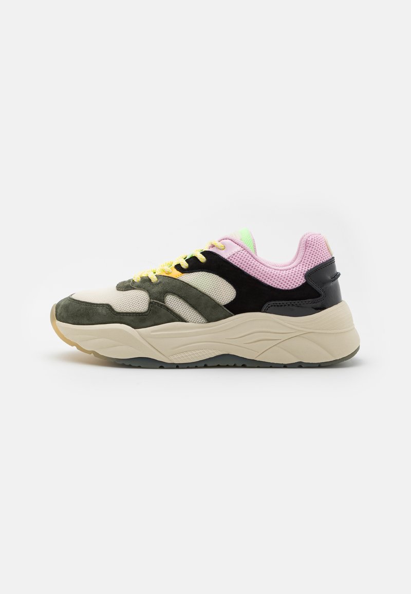 Sneaker basse avec panneaux superposés en mesh et suède verts, noirs, beige et rose, lacets jaunes et semelle épaisse crème, vue de côté sur fond blanc.
