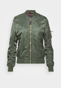 Blouson aviateur vert olive en satin lisse, doté d'une fermeture éclair dorée, de poignets côtelés et d'une poche zippée sur la manche gauche.