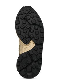 Spodní pohled na botu s černou vzorovanou gumovou podrážkou s vyvýšenými čtverci a béžovou mezipodrážkou s tečkovanými detaily.