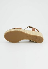 Hnědé kožené sandály s pletenými popruhy, strukturovaným klínem ve stylu lana a gumovou podrážkou. Disponují akcentem v podobě přezky ve zlaté barvě.