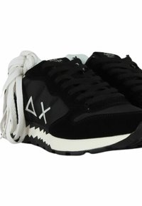 Sneaker nera caratterizzata da un mix di materiali scamosciati e in rete, lacci bianchi, suola a zigzag e logo bianco sul lato.