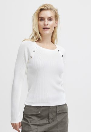 Hvid ribbet sweater med rund hals og lange ærmer, der har sølvknapdetaljer på skuldrene. Blød tekstur og tætsiddende design.