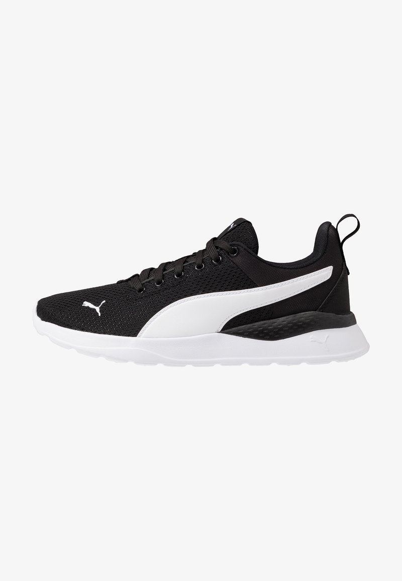 Chaussure de running basse noire et blanche avec tige en mesh, bande blanche avec logo sur le côté et semelle blanche avec languette au talon.