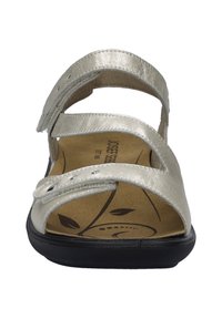 Srebrne metaliczne sandały z trzema regulowanymi paskami, wyściełaną podeszwą i czarną podeszwą zewnętrzną. Posiadają ozdobny wzór liścia na wkładce.
