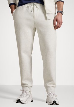 Hellgraue Sweatpants aus weichem Material, mit einem elastischen Bund und verstellbarem Kordelzug, seitlichen Taschen und schmal zulaufenden Bündchen.