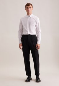 Witte geblokte overhemd met kraag, gecombineerd met op maat gemaakte zwarte broek met plooien en omgeslagen enkels. Zwarte schoenen maken de look af.