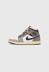 High-top sneaker in white, gray, and black suede with yellow and pink accents. Features a black swoosh and textured rubber sole.
