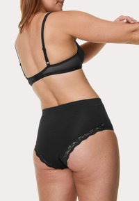 Svart lingerie-set med en behå med justerbara axelband och en trosor med spetsdetaljer, som visar upp en slät tyg och en klassisk design.