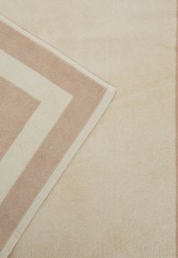 Tappetino da bagno texturizzato con una base beige, un morbido motivo a zig zag rosa e bordi in crema a contrasto. Tessuto assorbente con finitura morbida.