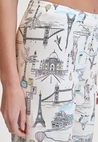 Leggings en coton avec un fond blanc et des croquis colorés sur le thème des voyages, y compris des monuments, des montgolfières et des palmiers.