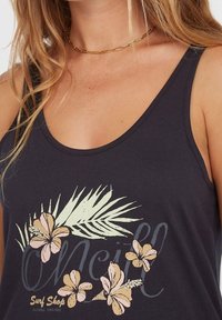 Top sin mangas oscuro con un ajuste relajado, que presenta un diseño floral en suaves tonos rosa y amarillo, junto con hojas de palma verdes y letras en negrita.
