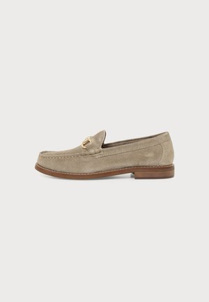 Mocassino da uomo in camoscio beige con dettaglio fibbia in metallo dorato e suola in legno marrone, mostrato di profilo su sfondo bianco.