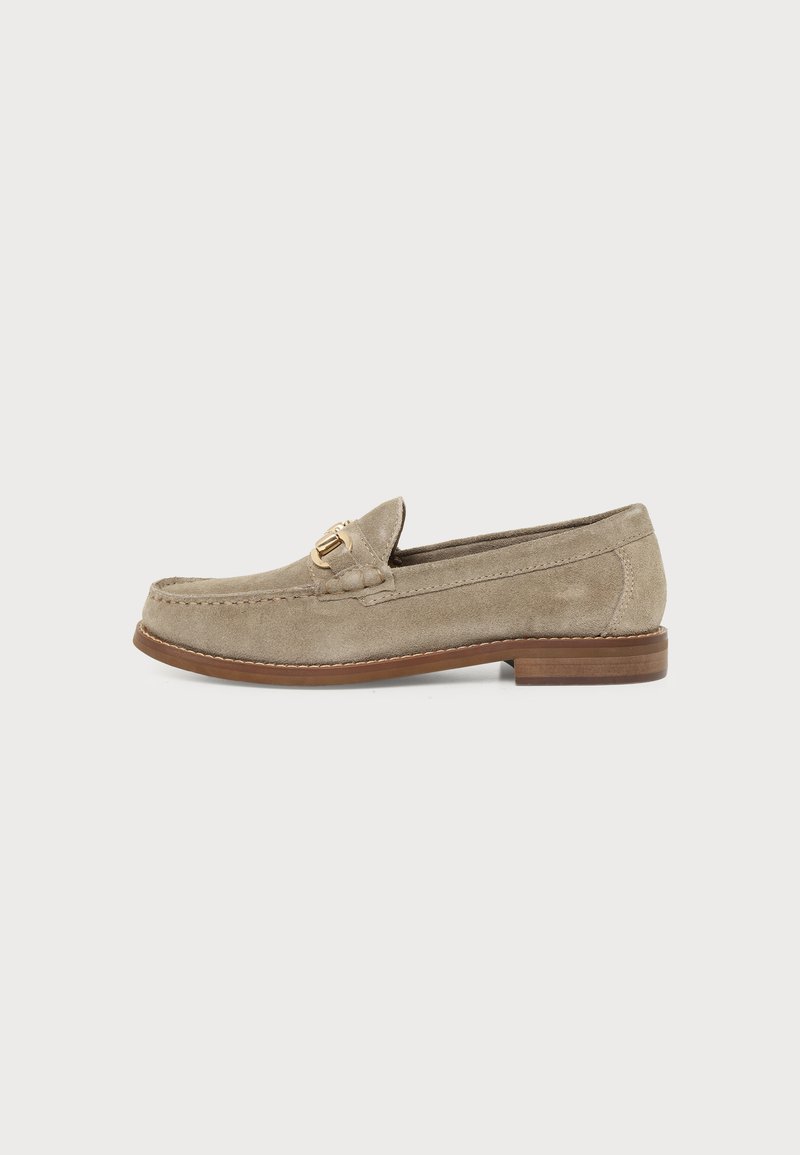 Mocassin homme en daim beige avec détail boucle métal doré et semelle en bois marron, montré de profil sur fond blanc.