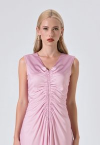 Rosa ärmelloses Kleid aus glattem Stoff, mit V-Ausschnitt, Falten entlang der Vorderseite und einer figurbetonten Silhouette.