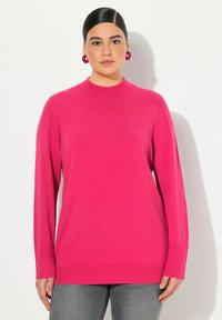 Fuksia neulepusero korkealla kauluksella, pitk ät hihat ja textured-helma. Yhdistetty harmaisiin farkkuihin. Sujuva neulekangas; ei näkyviä kuvioita tai metalliosia.