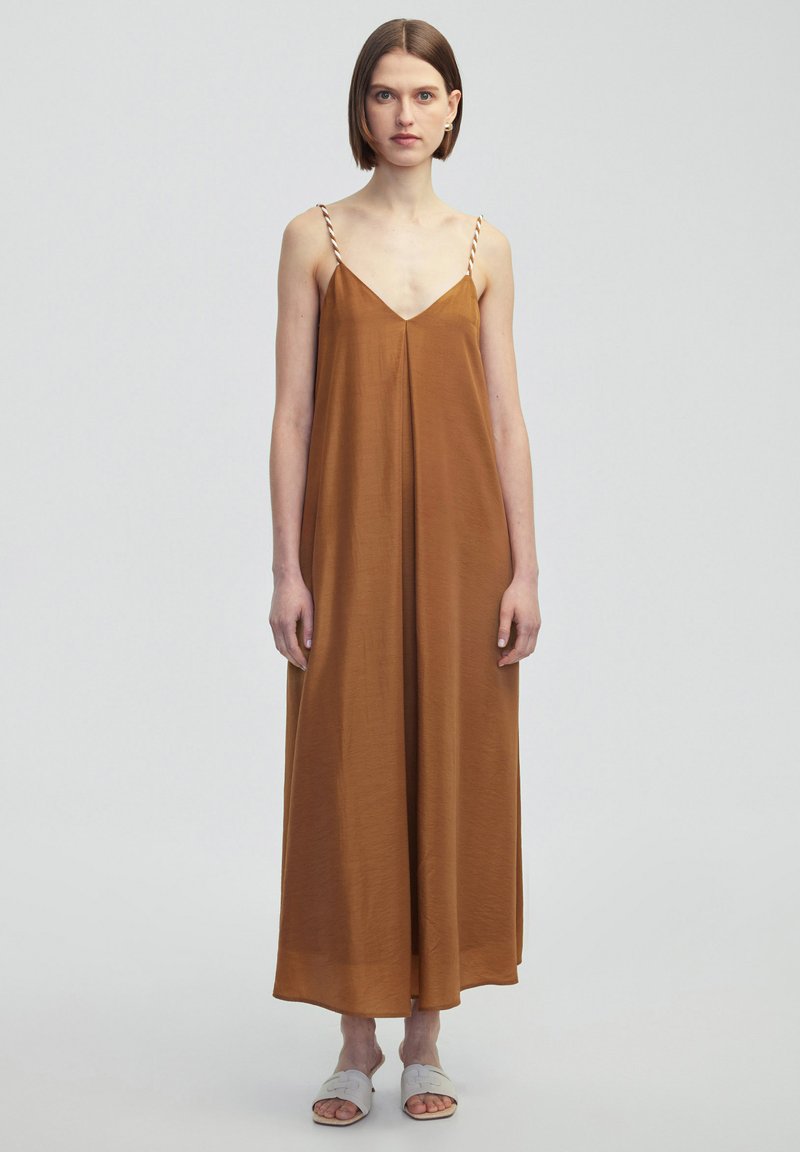 Vestido maxi sin mangas de color marrón con escote en V, que presenta tirantes finos y trenzados. Fabricado en una tela suave, tiene una silueta relajada y fluida.