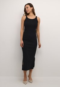 Black sleeveless midi dress with side slits. Made of smooth fabric, featuring a fitted silhouette and a rounded neckline.