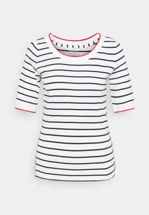 Weißes, figurbetontes Hemd mit schwarzen horizontalen Streifen, Ärmeln bis zum Ellbogen und rotem Besatz am Ausschnitt und an den Ärmelsäumen.