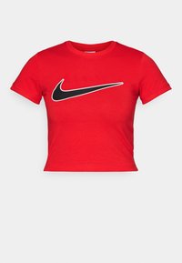 Czerwony krótki t-shirt z bawełny, z czarnym logo Nike w formie znaku Swoosh nadrukowanym na piersi. Krótkie rękawy.