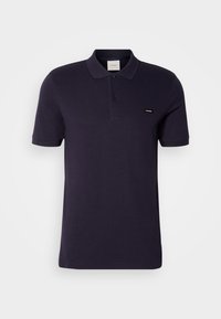 Polo noir à manches courtes avec col, deux boutons et petite étiquette de marque sur la poitrine gauche sur fond uni.