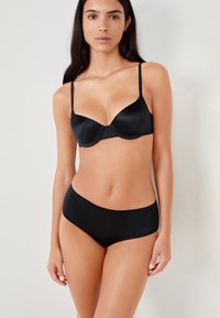 Black bra and high-waisted panties set. Smooth fabric, seamless design, adjustable straps on the bra, minimalistic silhouette.