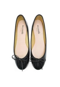 Ballerine in vernice nera con punta rotonda, rifinitura in tessuto sottile e un fiocco decorativo sulla parte anteriore. Morbido rivestimento interno beige.