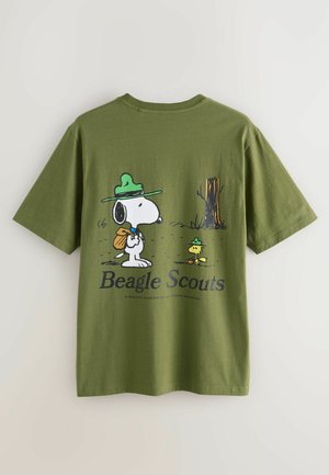 Kortärmad olivgrön t-shirt med en tecknad grafisk bild av en hund och en fågel med ryggsäck och hattar. Texten säger "Beagle Scouts."