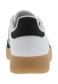 Sneaker bianca con accenti neri e verdi, tallone posteriore texturizzato e suola in gomma. Presenta una parte superiore in sintetico liscio e un colletto imbottito.