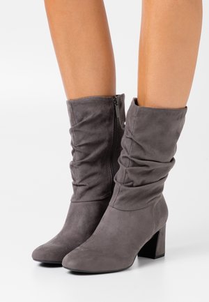 Szare zamszowe botki za kostkę z luźnym fasonem, blokowym obcasem, elastycznym marszczeniem u góry i ozdobnym suwakiem po boku.