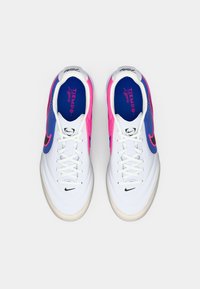 Ζευγάρι λευκών ποδοσφαιρικών παπουτσιών Nike Tiempo Legend με μπλε και ροζ λεπτομέρειες, λευκές κορδόνες και μαύρα λογότυπα swoosh, σε προοπτική από πάνω.