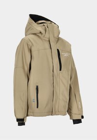 Beige Softshelljacke mit Kapuze, ausgestattet mit zwei seitlichen Reißverschlusstaschen, einer Brusttasche und einem schwarzen Innenfutter. Mit Logo- und schwedischer Flaggenapplikation.